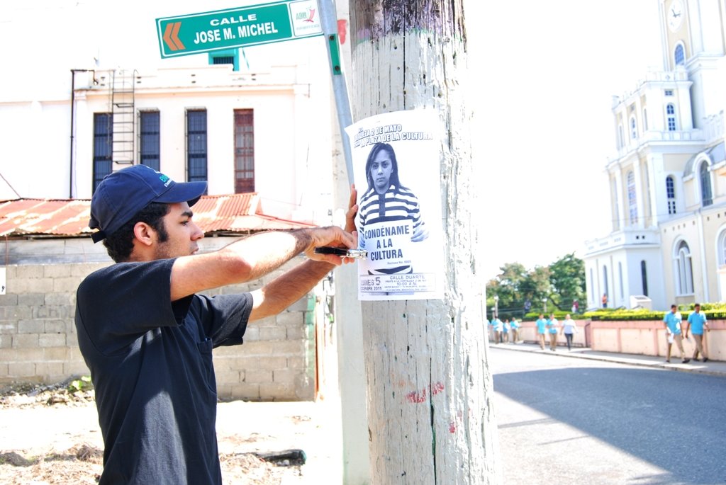 Elvys Rodríguez pega afiche de No a la cárcel 2 de mayo